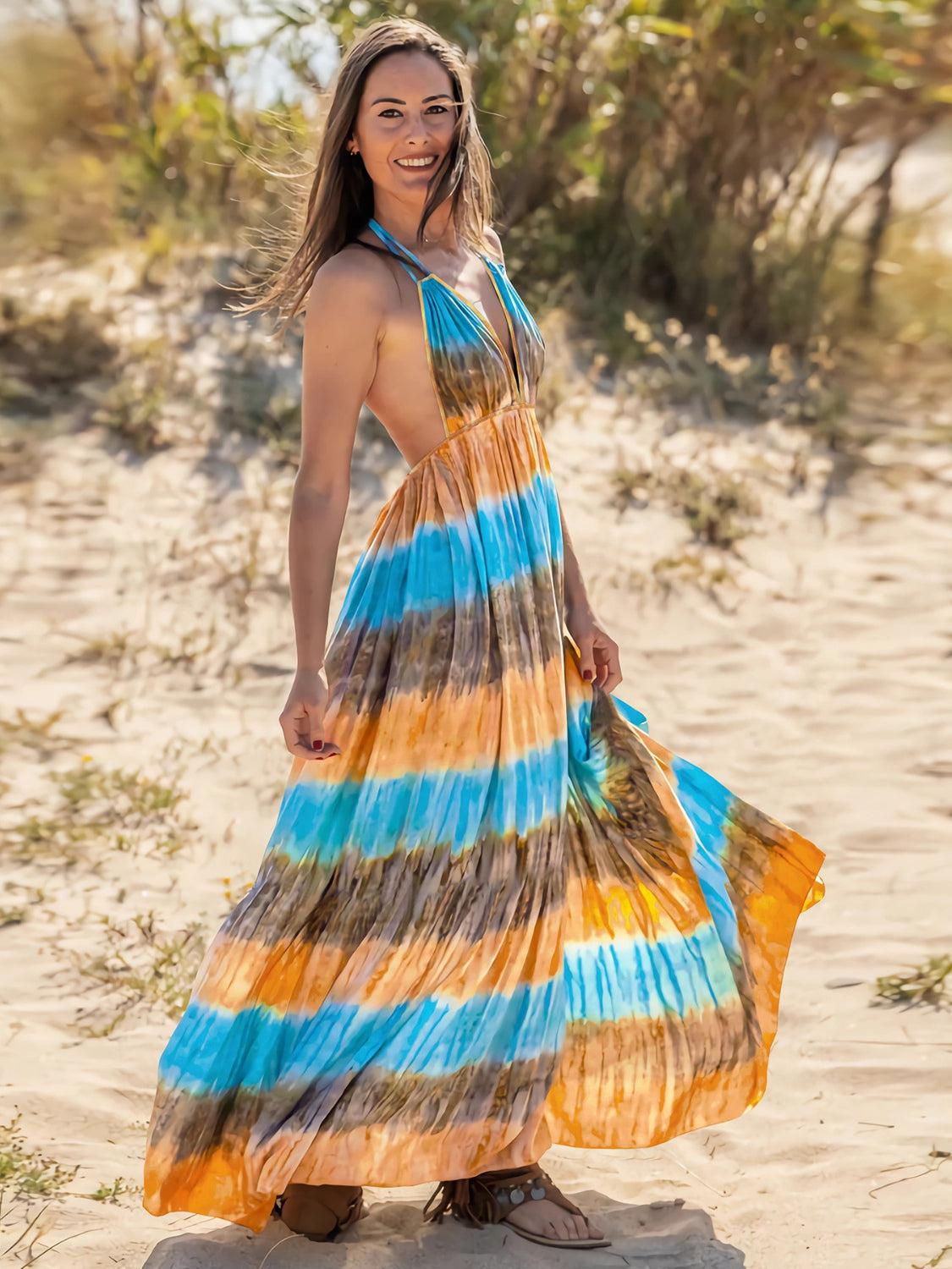 a woman standing on a beach wearing a colorful dress