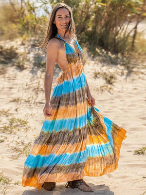 a woman standing on a beach wearing a colorful dress