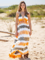 a woman standing on a beach wearing a dress