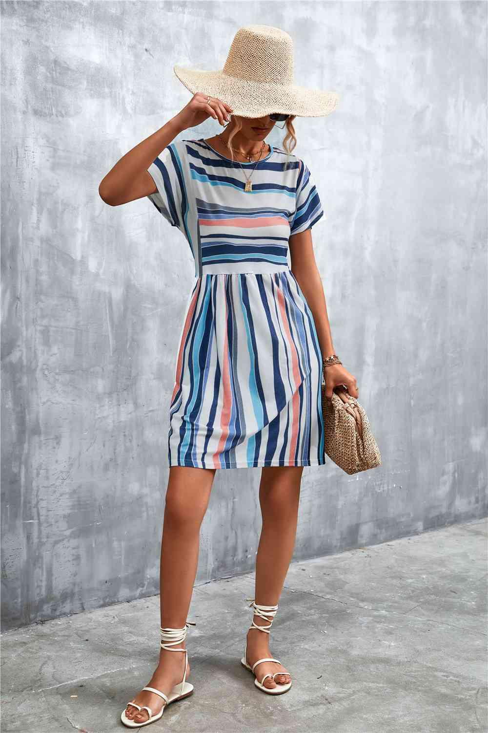 a woman in a striped dress and straw hat