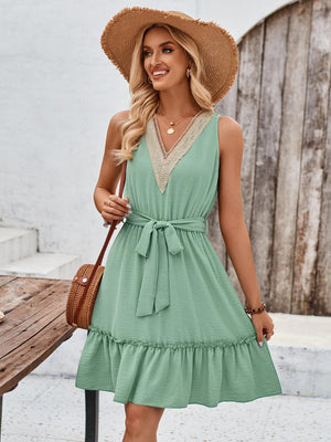 a woman wearing a green dress and a straw hat