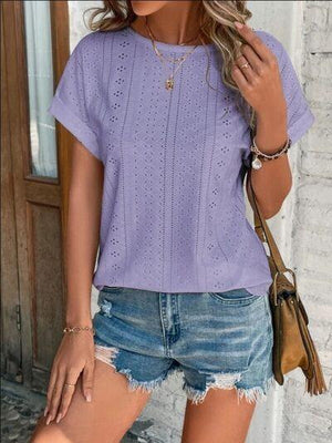 a woman wearing a purple shirt and denim shorts