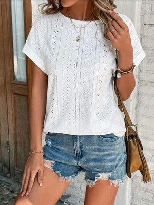 a woman wearing a white top and denim shorts