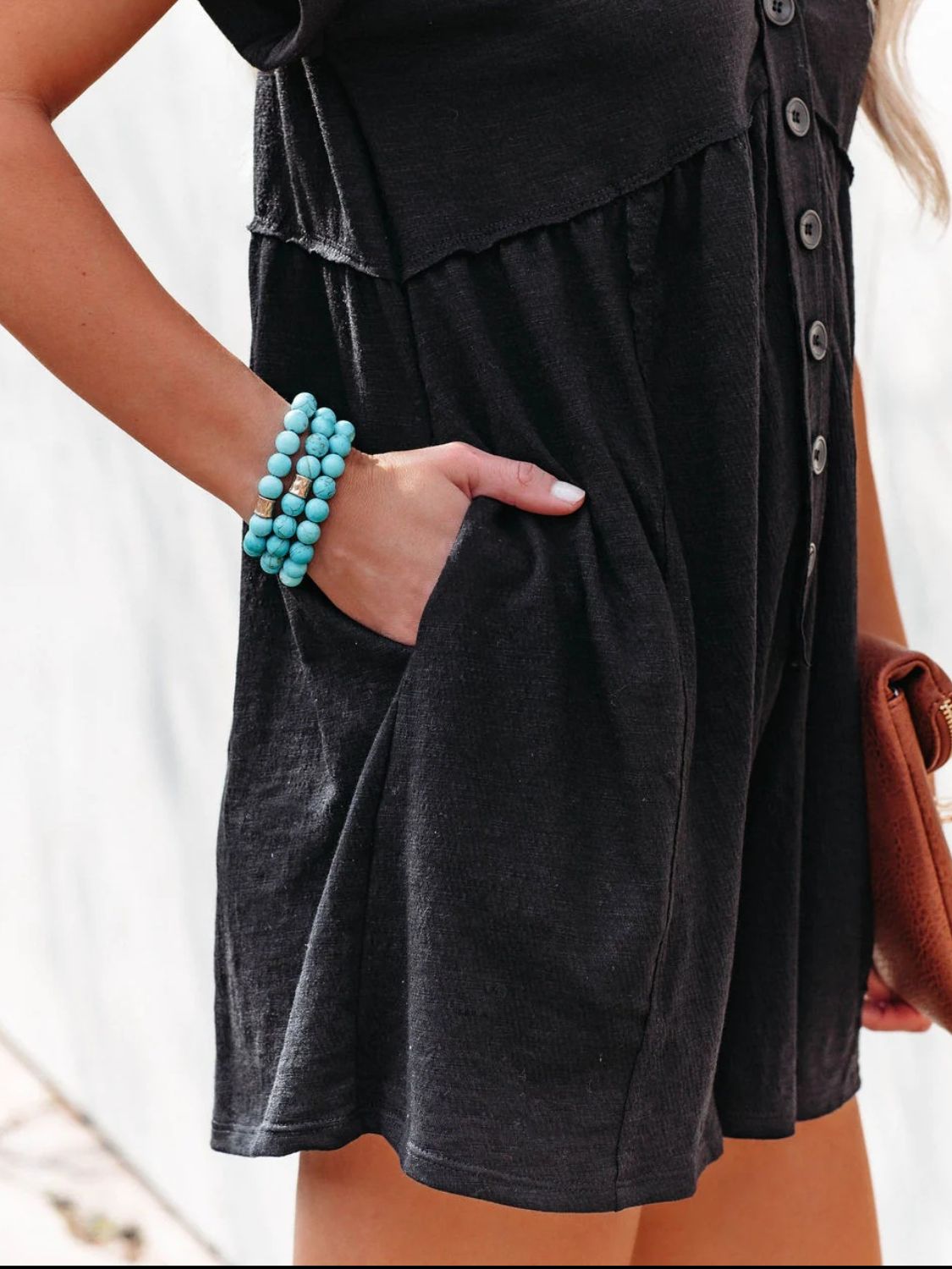 a woman wearing a black dress and a turquoise beaded bracelet