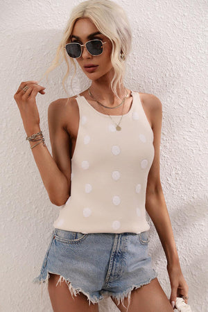 a woman wearing a white polka dot tank top