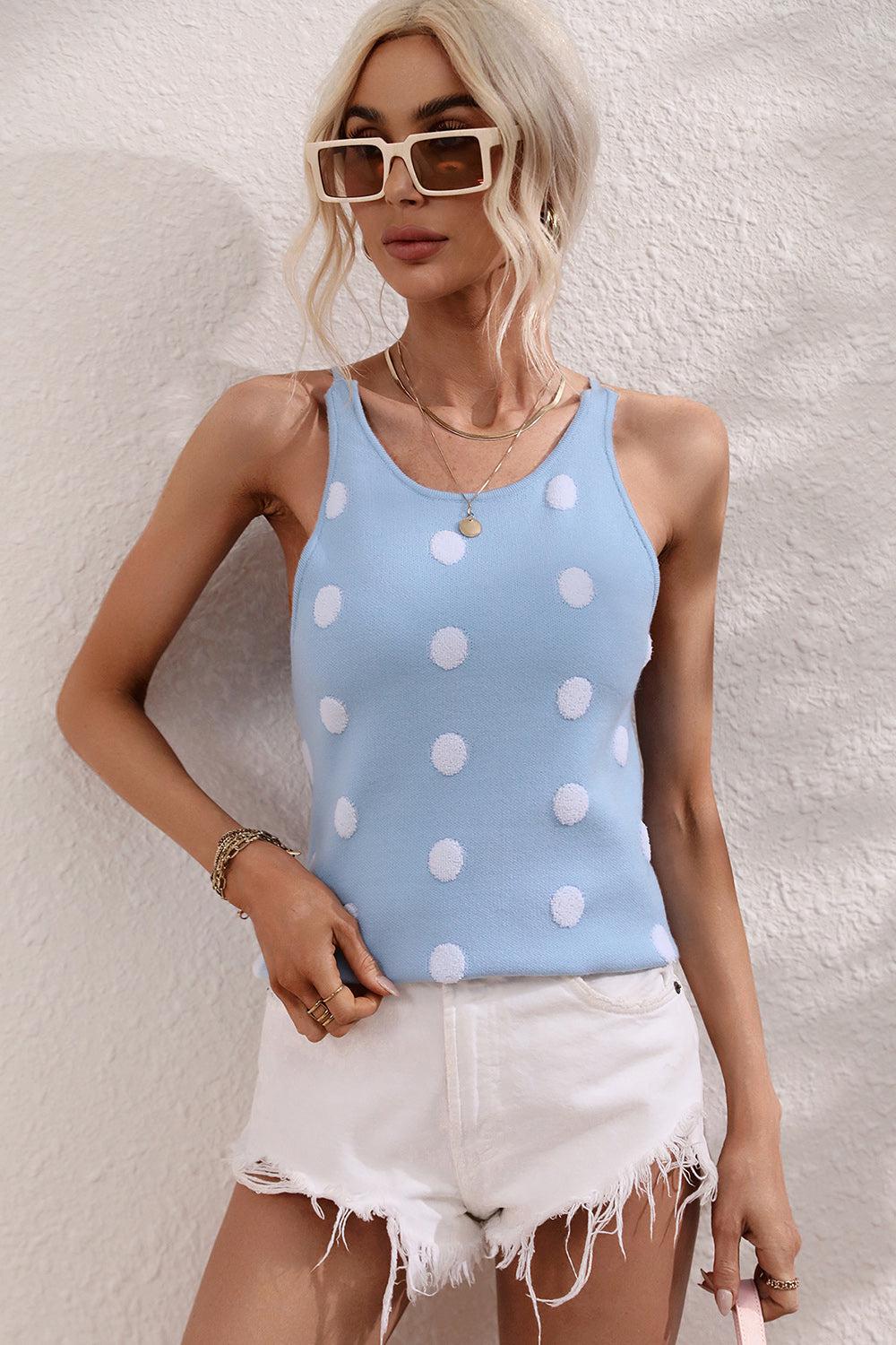 a woman wearing a blue tank top with white polka dots