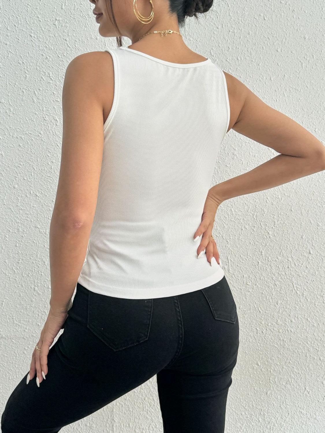 a woman in black pants and a white tank top