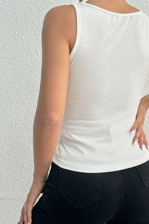 a woman wearing a white top and black pants