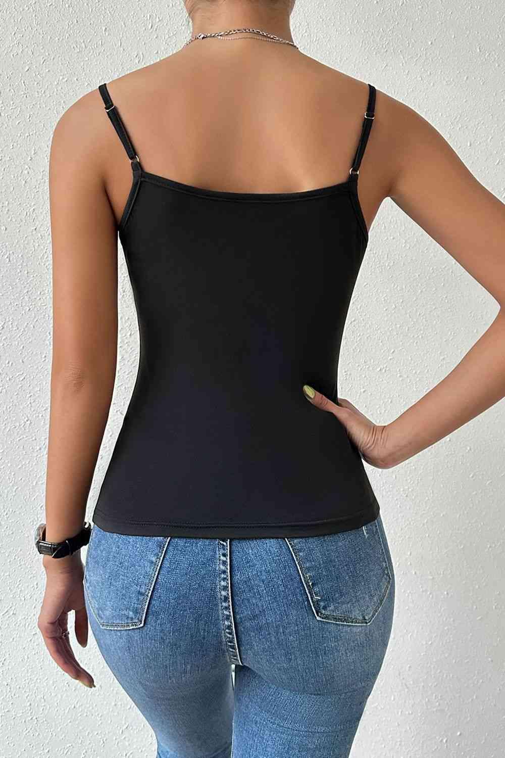 a woman wearing a black tank top and jeans