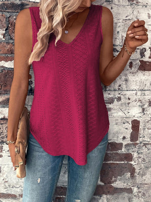 a woman wearing a pink top standing against a brick wall