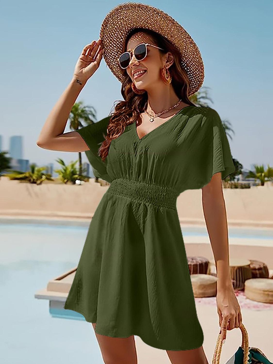 a woman in a green dress and straw hat