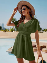 a woman in a green dress and straw hat