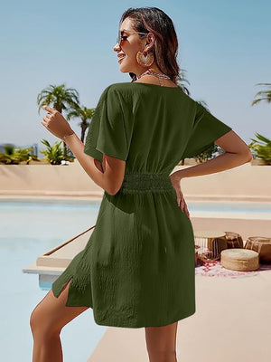 a woman in a green dress standing by a pool