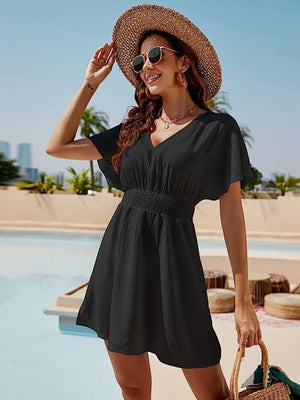 a woman in a hat and sunglasses standing by a pool