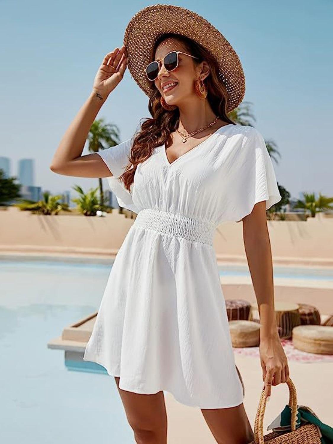 a woman in a white dress and straw hat