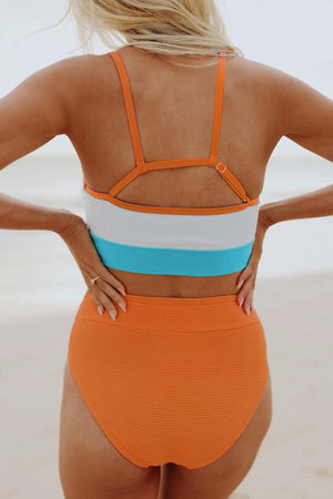 a woman in an orange and blue one piece swimsuit