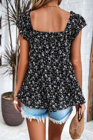 a woman wearing a black and white floral top