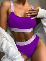 a woman in a purple bikini top and white towel