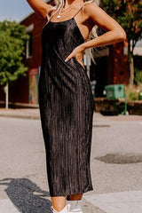 a woman wearing a black dress and white sneakers