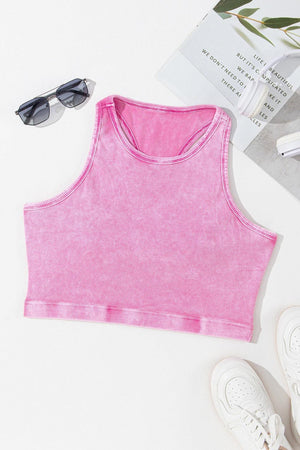 a pink crop top next to a pair of sunglasses