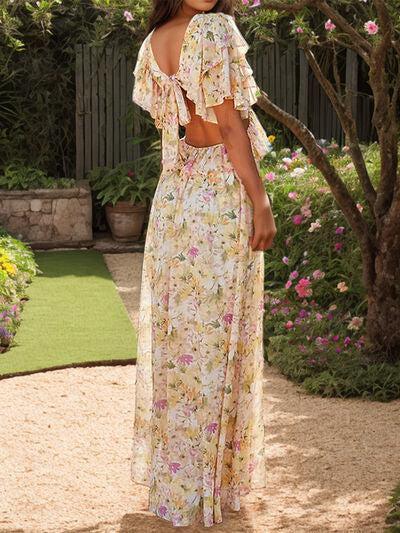 a woman standing in a garden wearing a floral dress