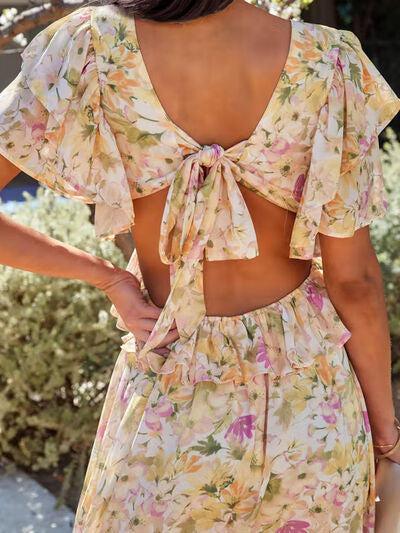 a woman wearing a floral dress with a back cut out