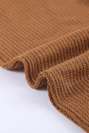 a close up of a brown sweater on a white surface