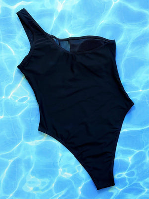 a black one piece swimsuit laying on top of a swimming pool