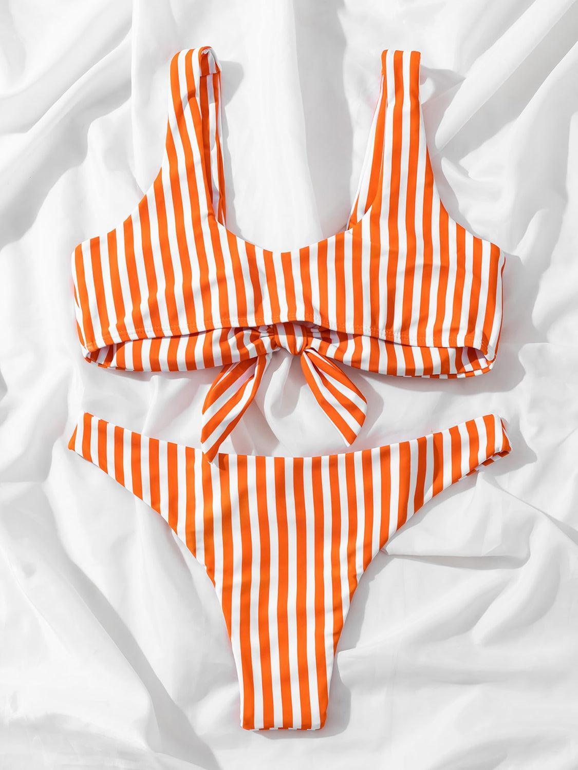 an orange and white striped bikini on a white sheet