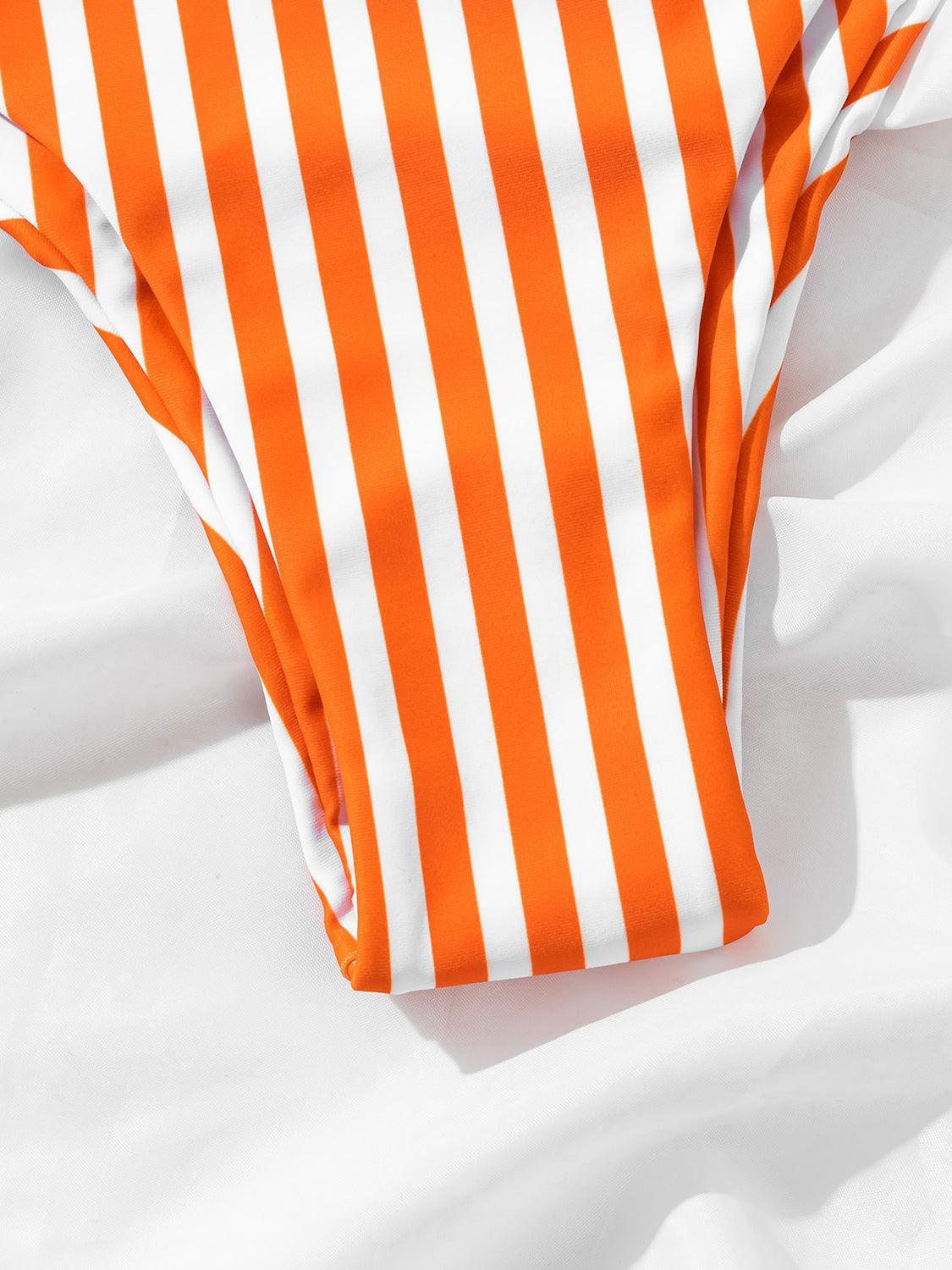 an orange and white striped tie laying on a white sheet