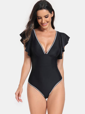 a woman wearing a black swimsuit with white trim