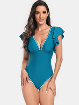 a woman in a blue swimsuit posing for the camera