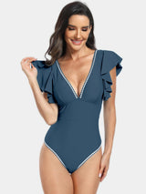 a woman wearing a blue swimsuit with white trim