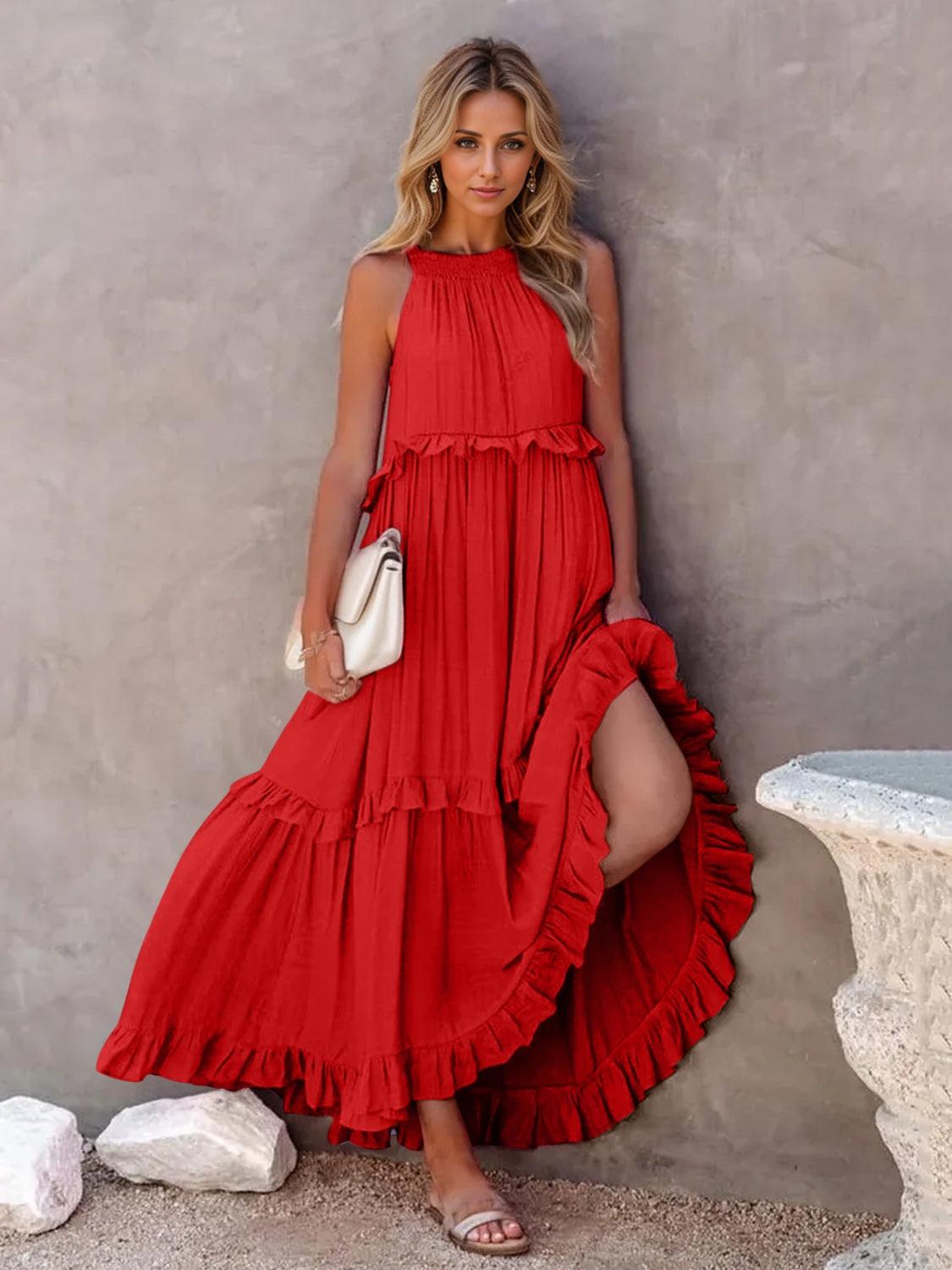 a woman in a red dress leaning against a wall