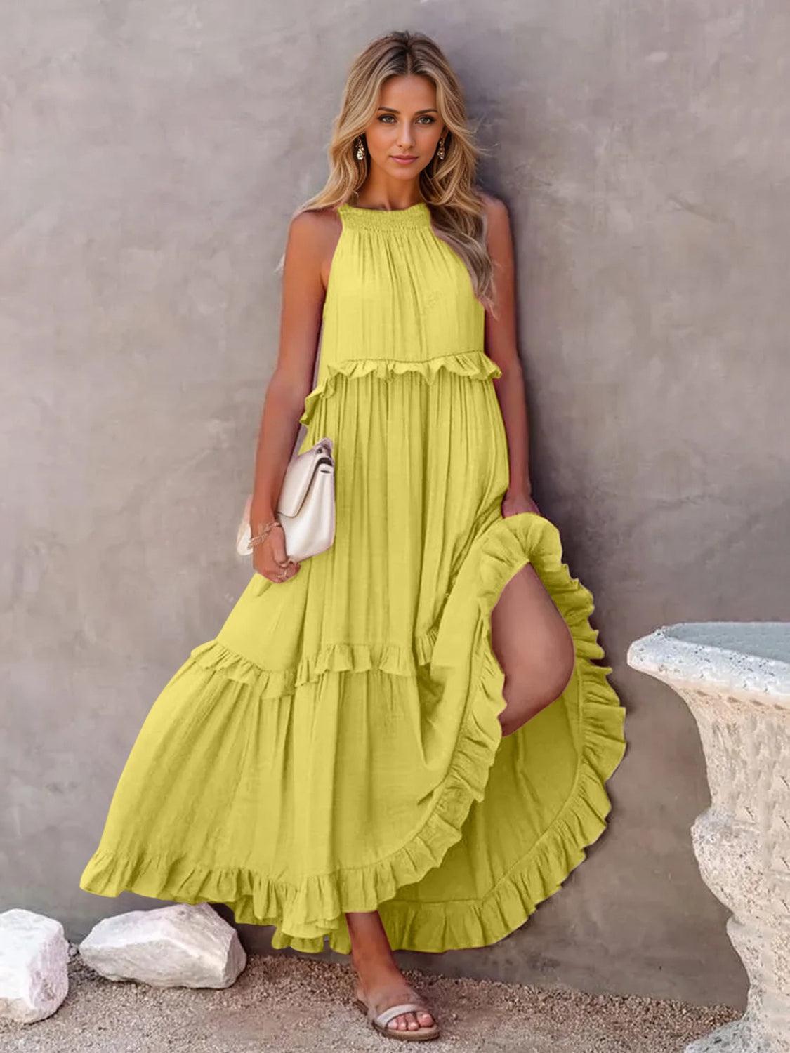 a woman in a yellow dress leaning against a wall