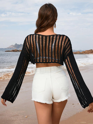 a woman walking along a beach next to the ocean