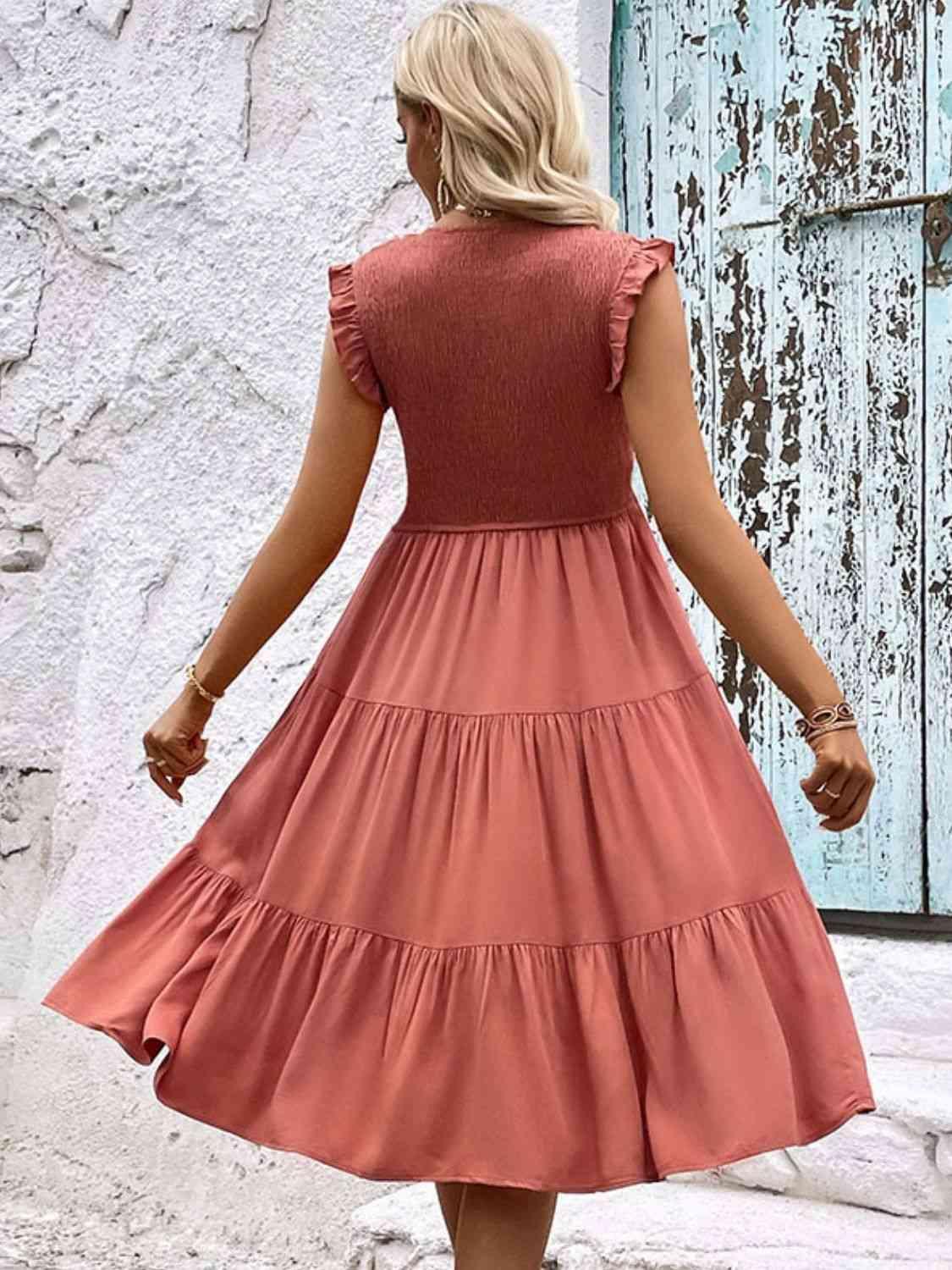 a woman in a pink dress walking down a street