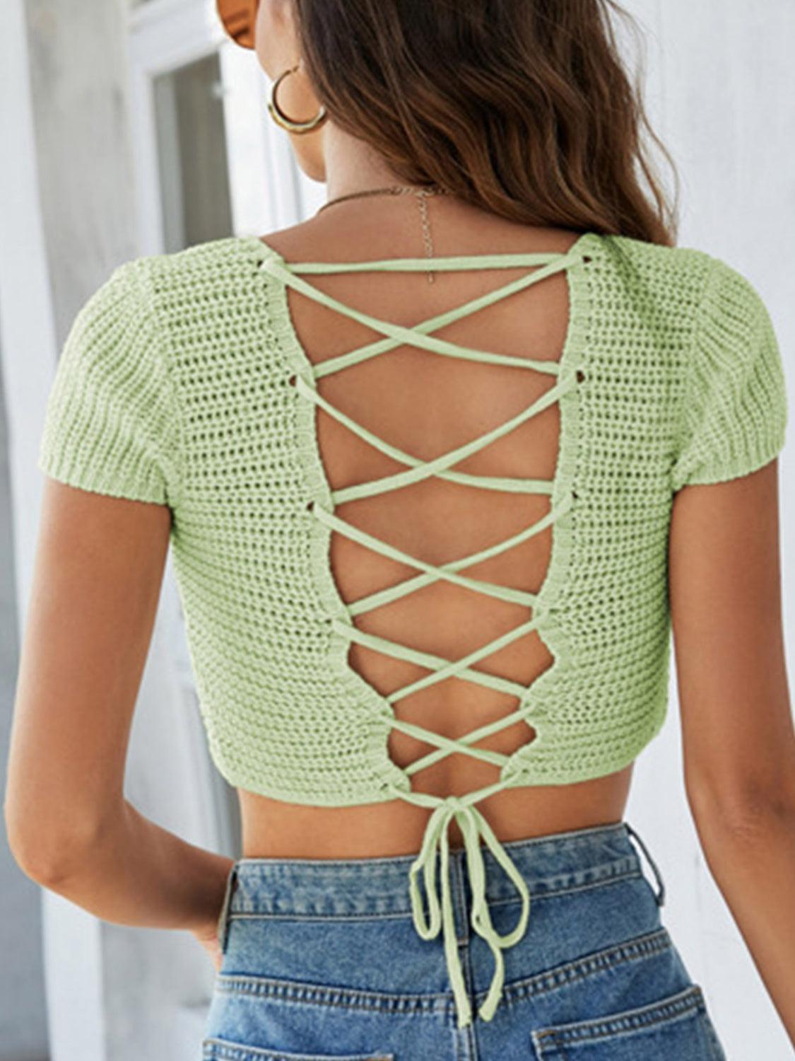 a woman wearing a green top with a lace up back