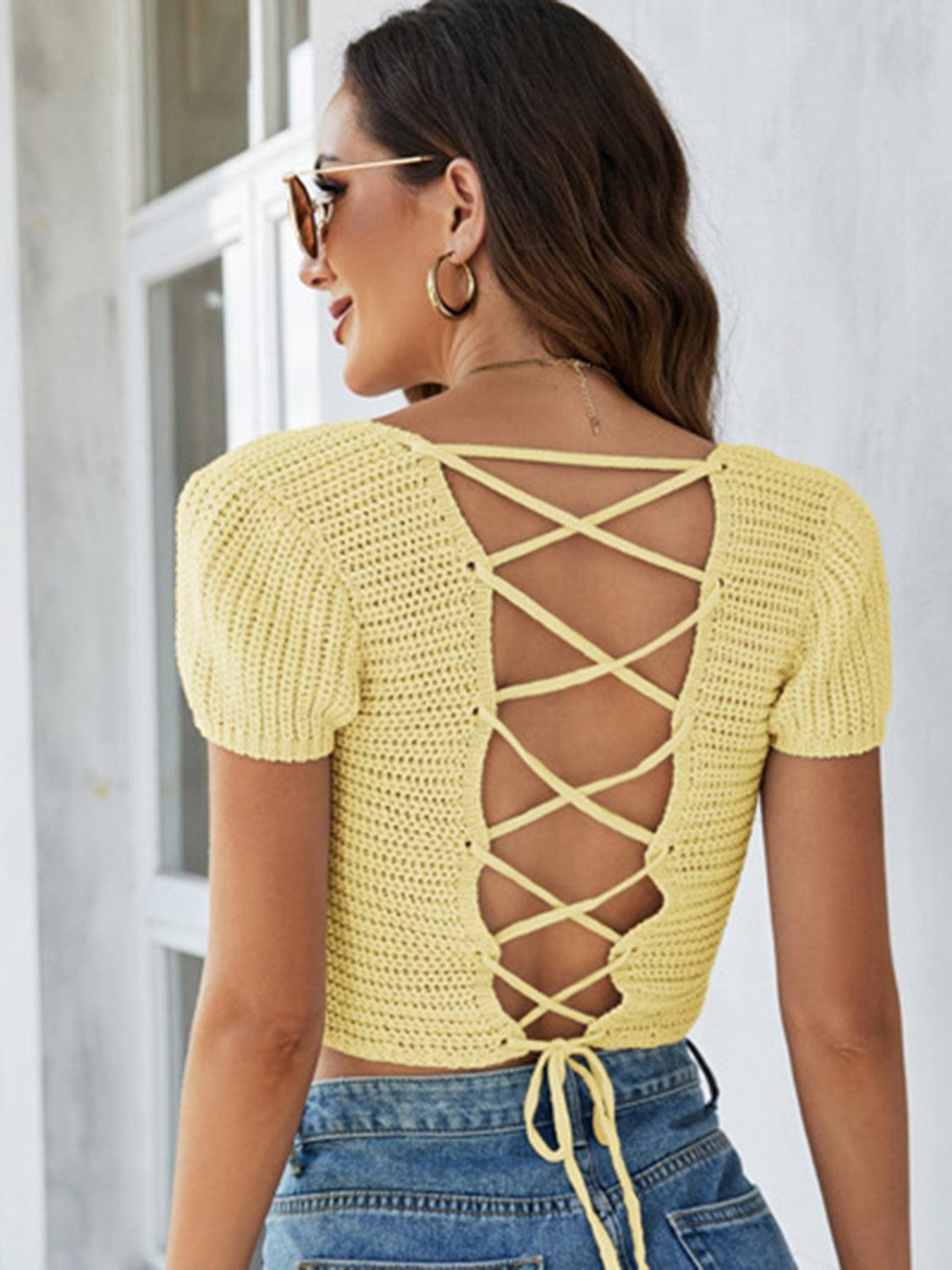 a woman wearing a yellow top with a lace up back