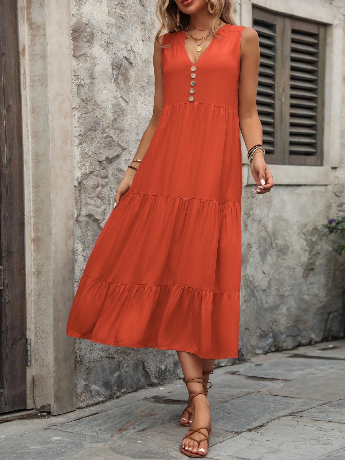 a woman in an orange dress standing on a sidewalk