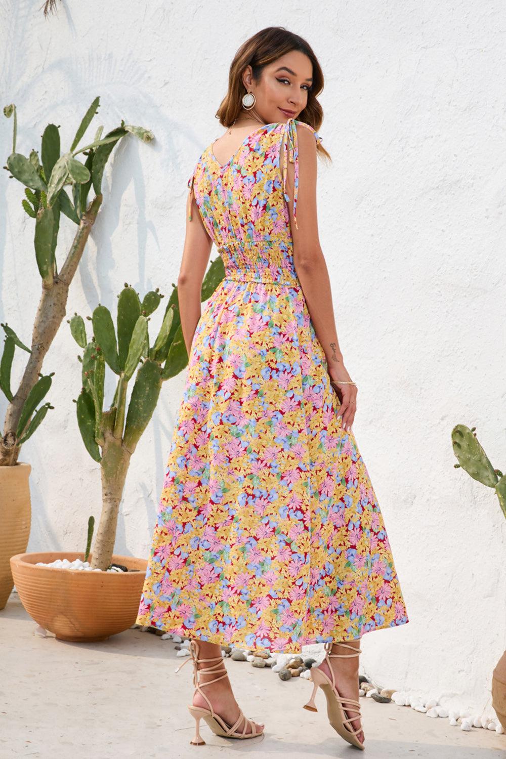 a woman in a floral dress standing in front of a cactus