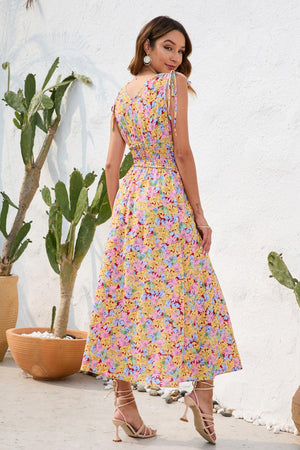 a woman in a floral dress standing in front of a cactus