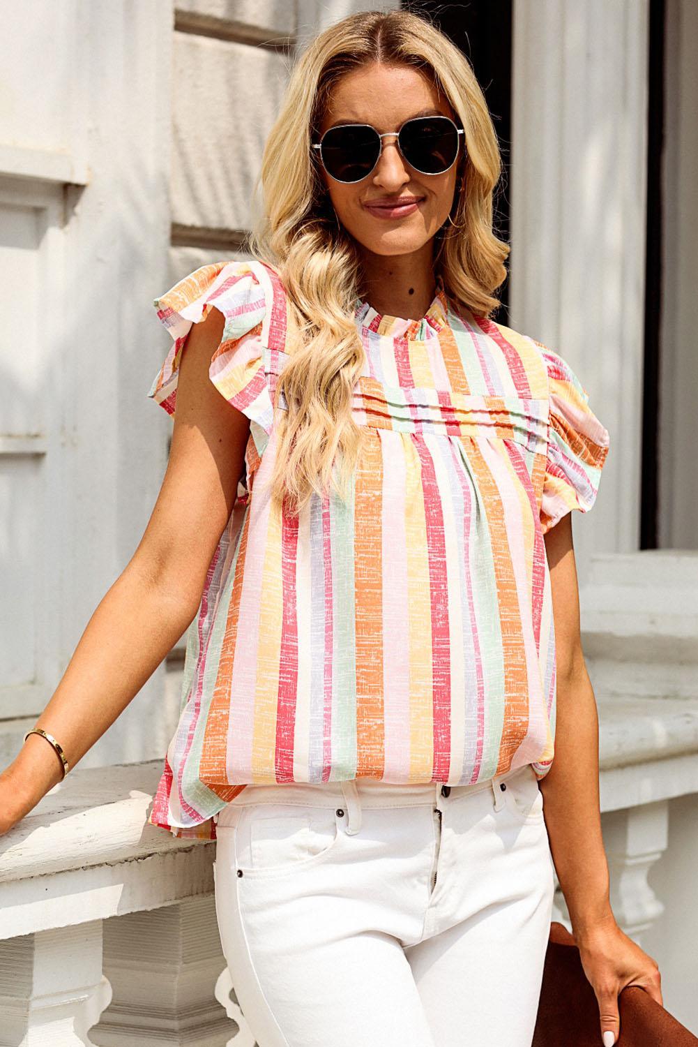 a woman wearing a striped top and white pants