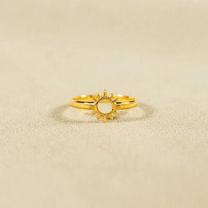 a gold ring with a sun design on it