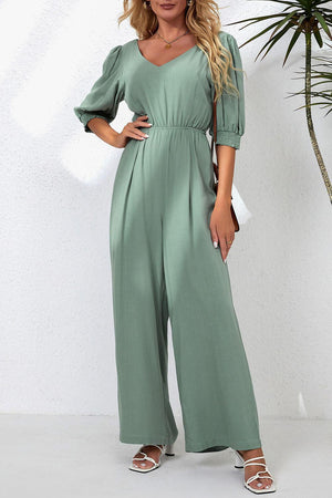 a woman in a green jumpsuit posing for the camera