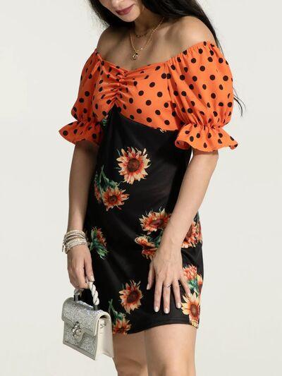 a woman in an orange and black dress holding a purse