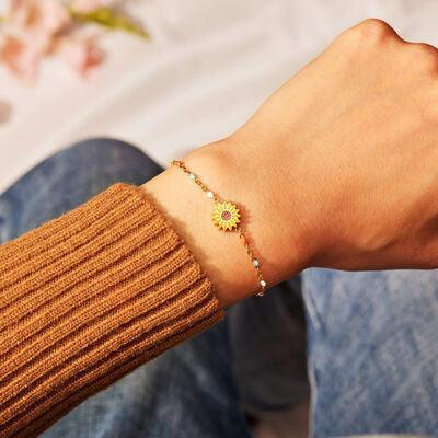 a person wearing a bracelet with a flower on it