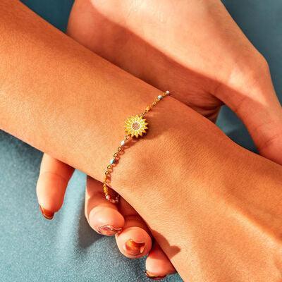 a woman's hand holding a bracelet with a sunflower on it