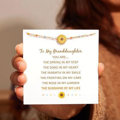 a woman holding up a card with a sunflower on it