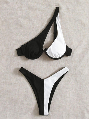 a pair of black and white bikinis laying on top of a bed